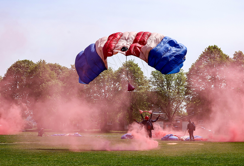 A Falcon lands amidst billowing red smoke